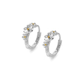 A pair of two-tone sterling silver and gold plate daisy hoop earrings, shown at an angle on a white background.